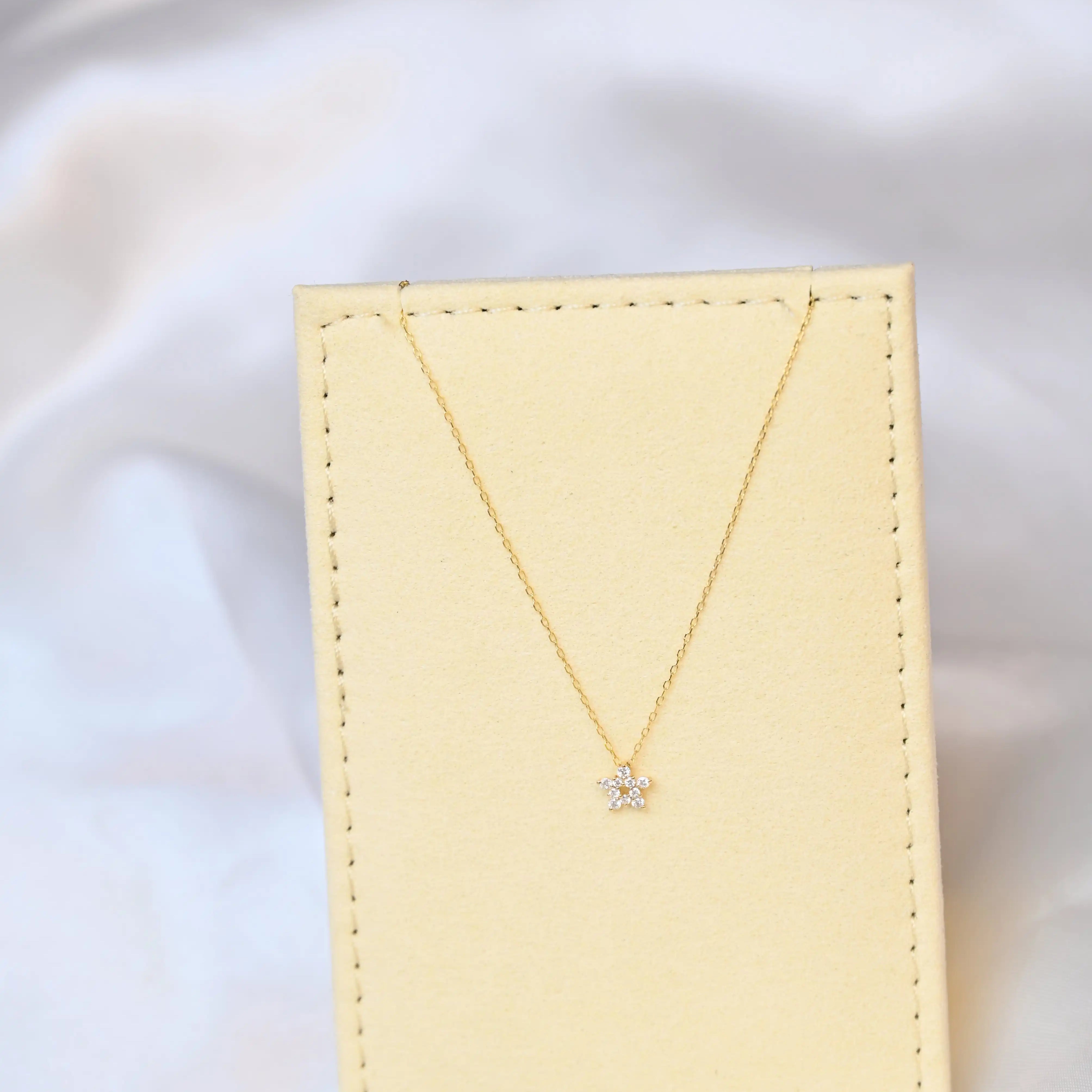 Crocus Diamond Necklace in 18K gold with 13 sparkling SI clarity on a beige jewelry display