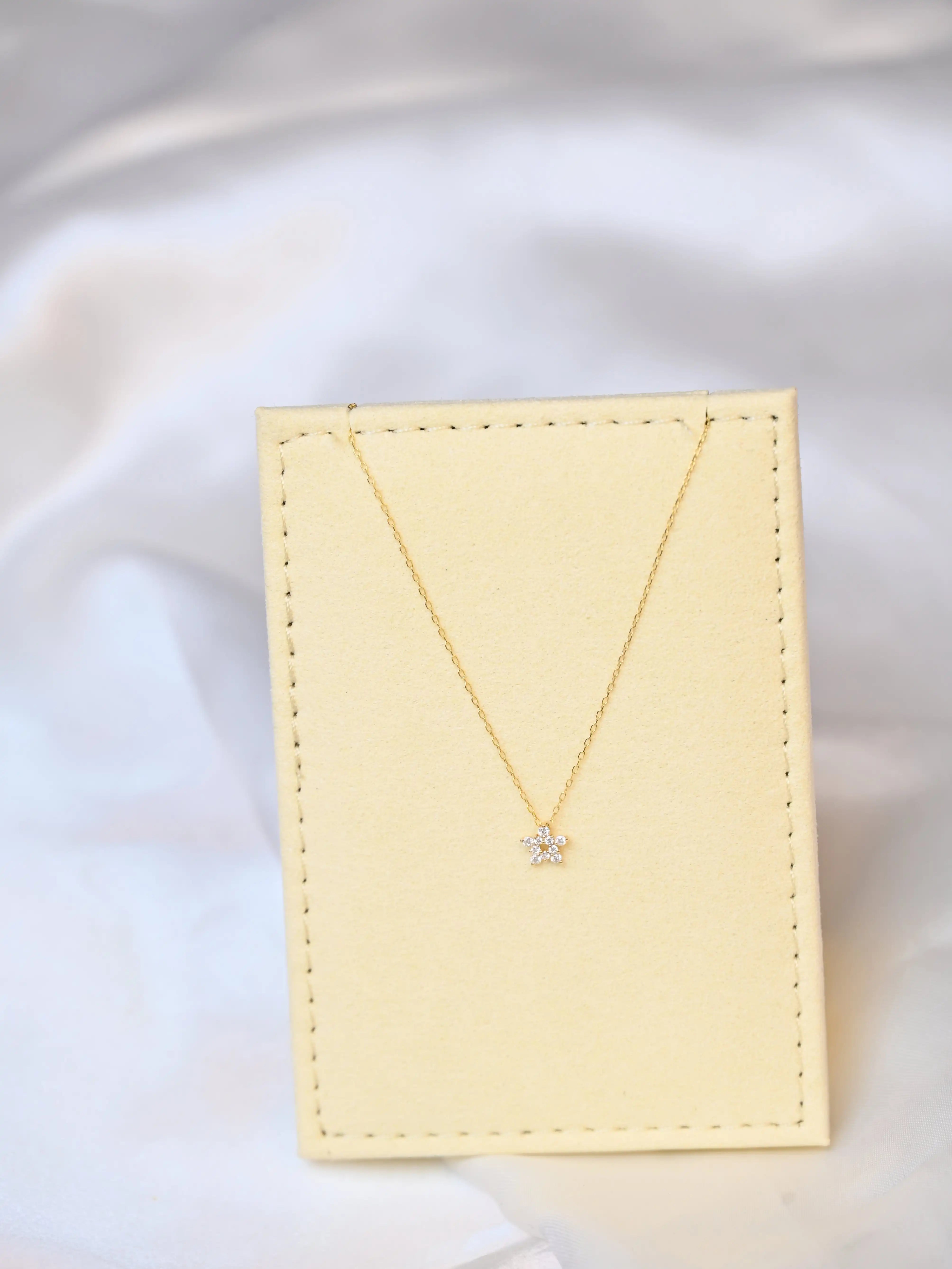 Crocus Diamond Necklace in 18K gold with 13 sparkling SI clarity on a beige jewelry display