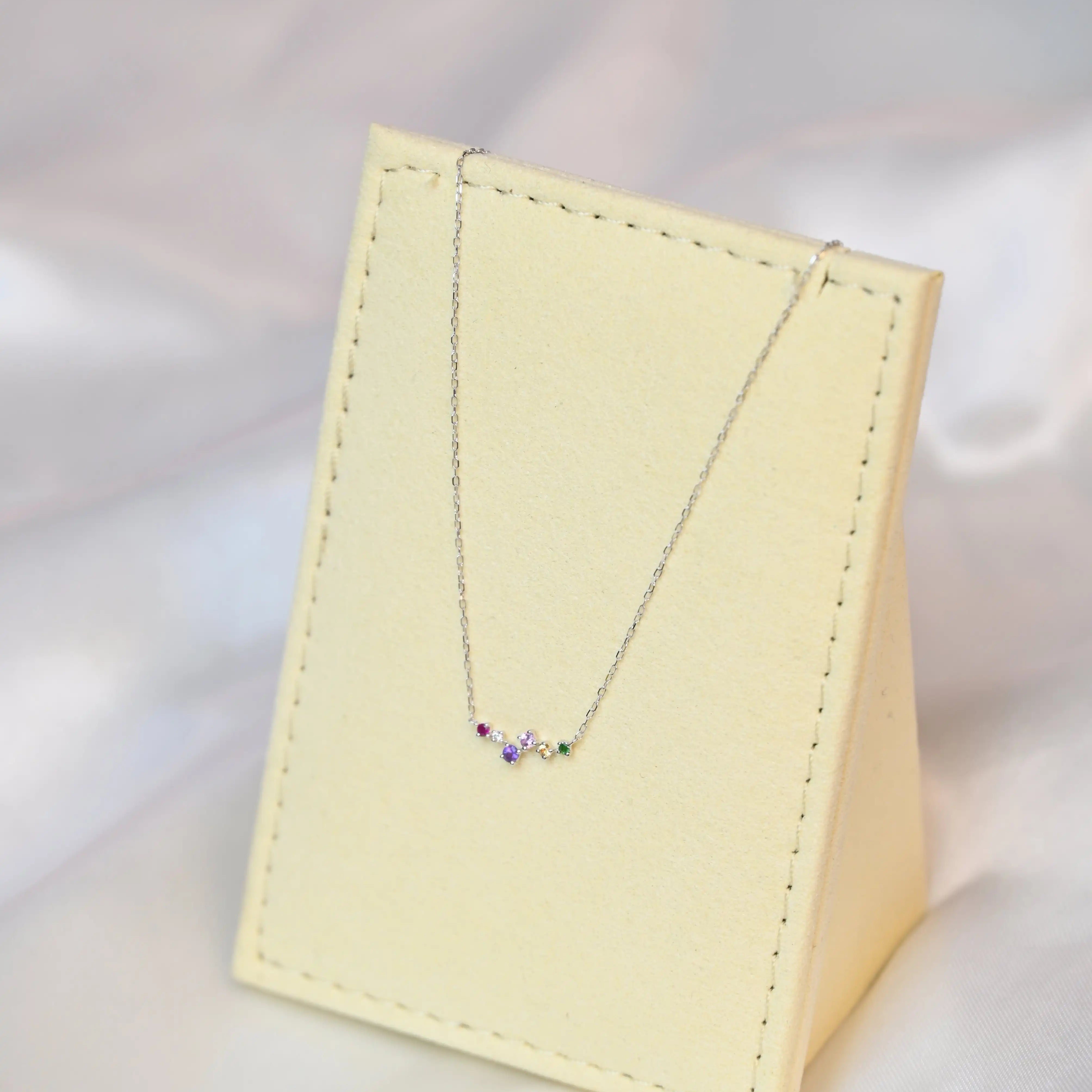 Devina Multi-Gem Diamond Necklace on a jewelry display tilting to the left