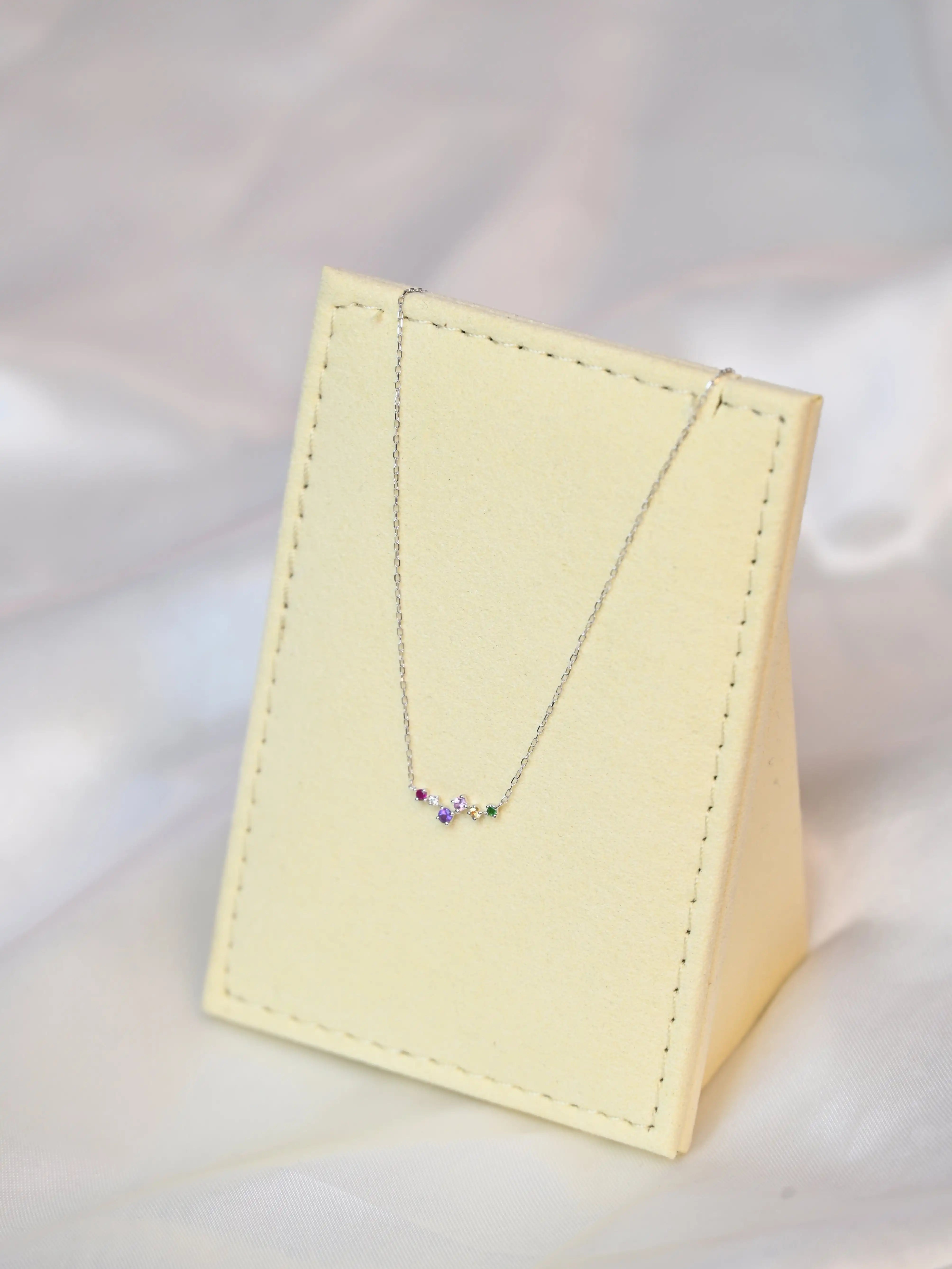 Devina Multi-Gem Diamond Necklace on a jewelry display tilting to the left