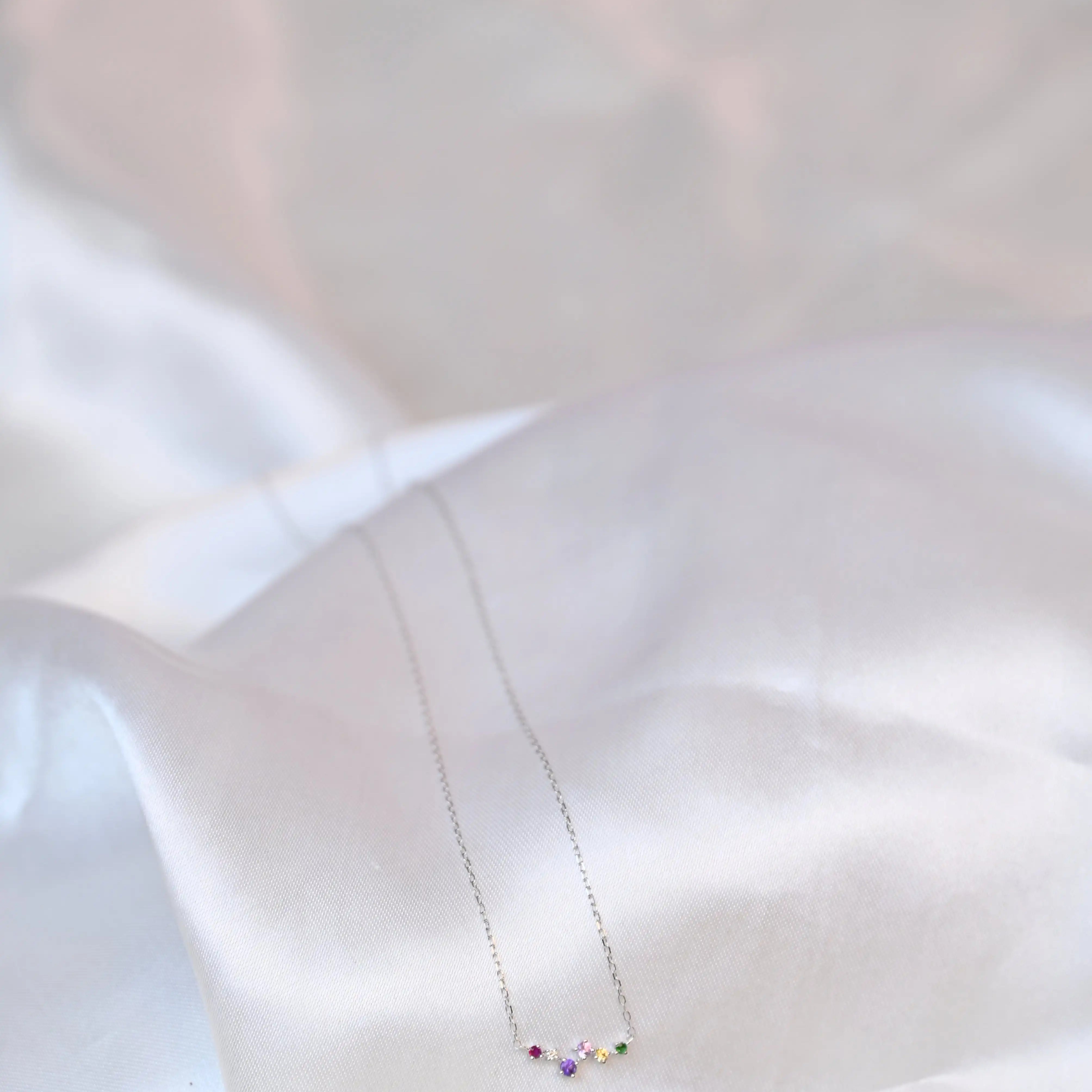 Devina Multi-Gem Diamond Necklace on a silky grey cloth background