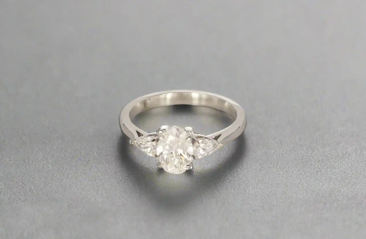 Eglah Engagement Ring with oval-cut diamond set in 14K White gold ona black leather background