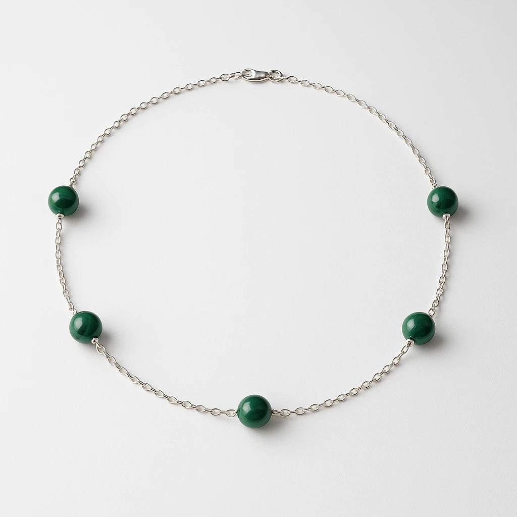 Silver bracelet with Malachite green beads on a white background