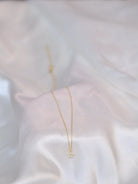 Crocus Diamond Necklace in 18K gold with 13 sparkling SI clarity on a white silk display background