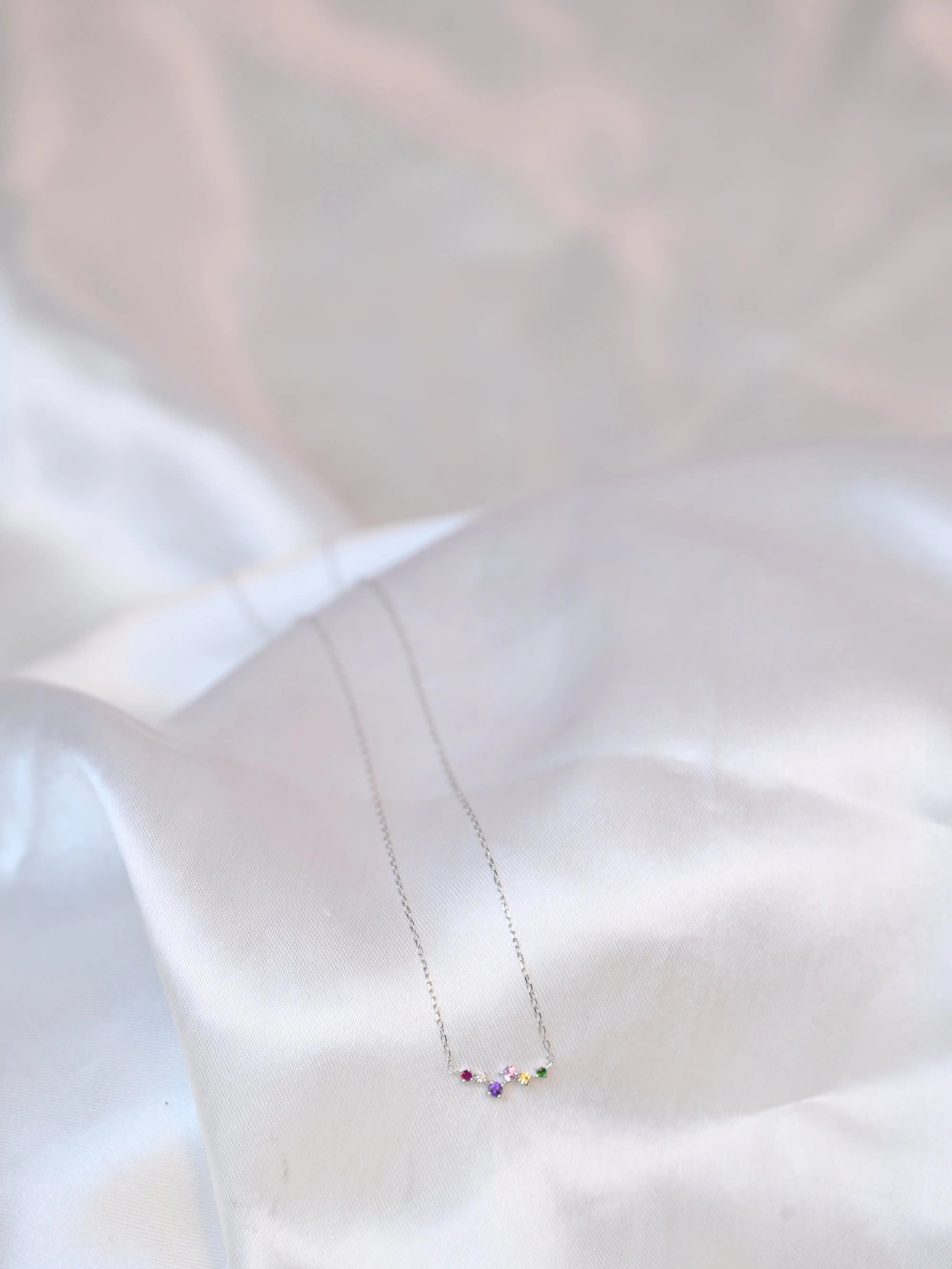 Devina Multi-Gem Diamond Necklace on a silky grey cloth background